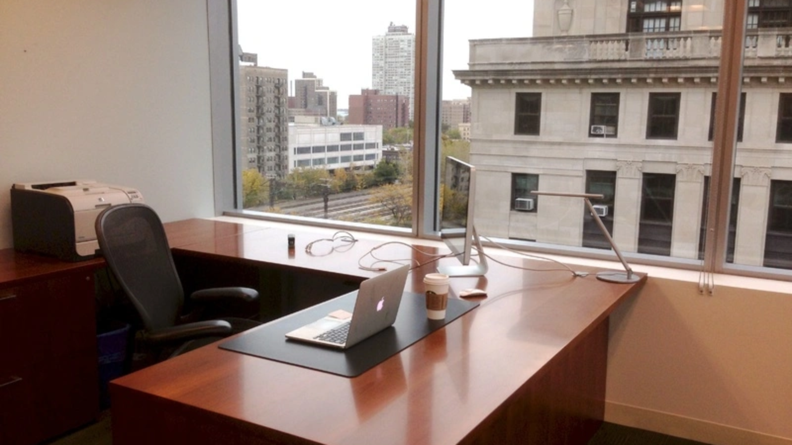 Office Desk with Laptop and Coffee Cup with Cityscape View